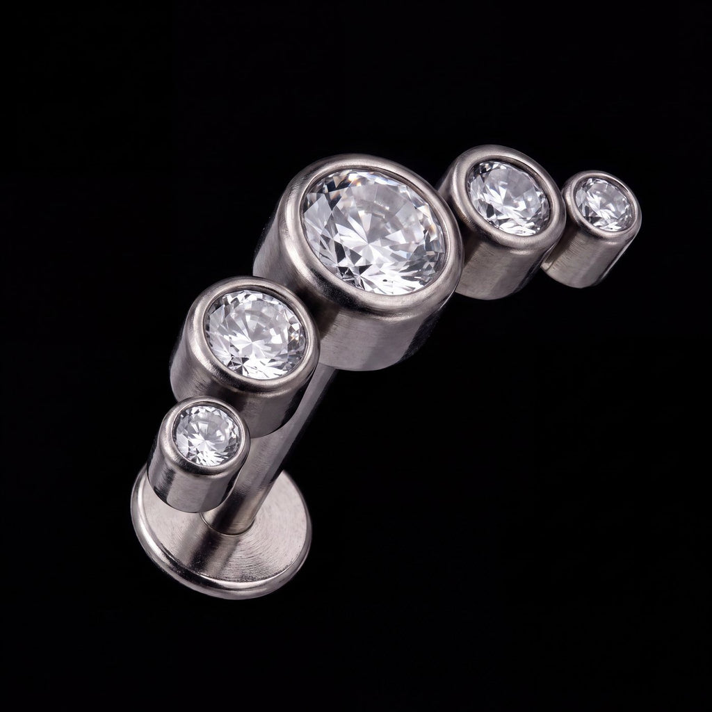 Lyra — Five bezel-set stones in a rising arc
